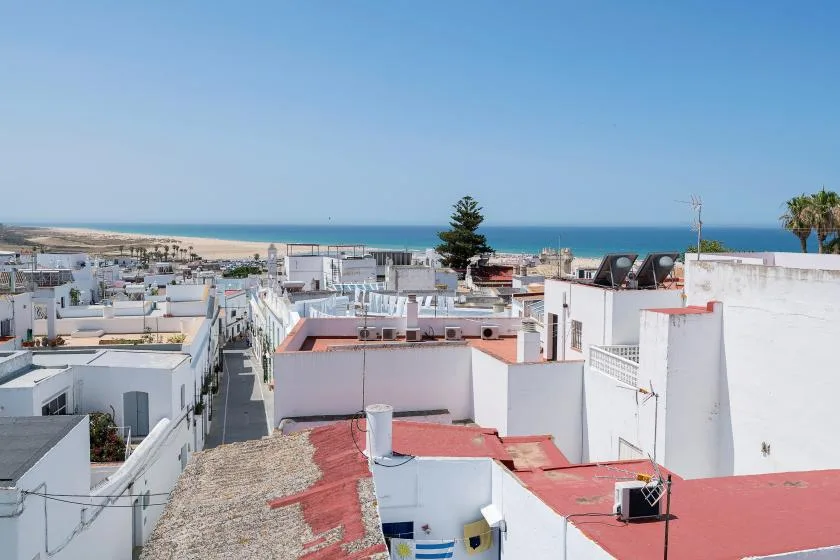 A coastal neighborhood of white buildings sits beneath a clear sky.