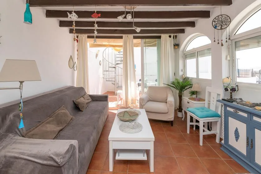 A bright living room with seating, a coffee table, and large arched windows.