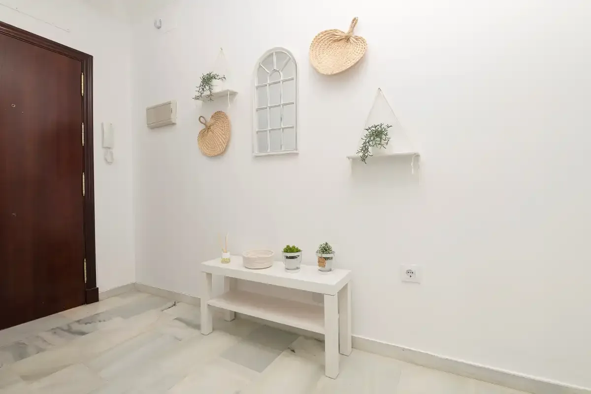 A bright entryway with a dark wooden door and a small white console table.