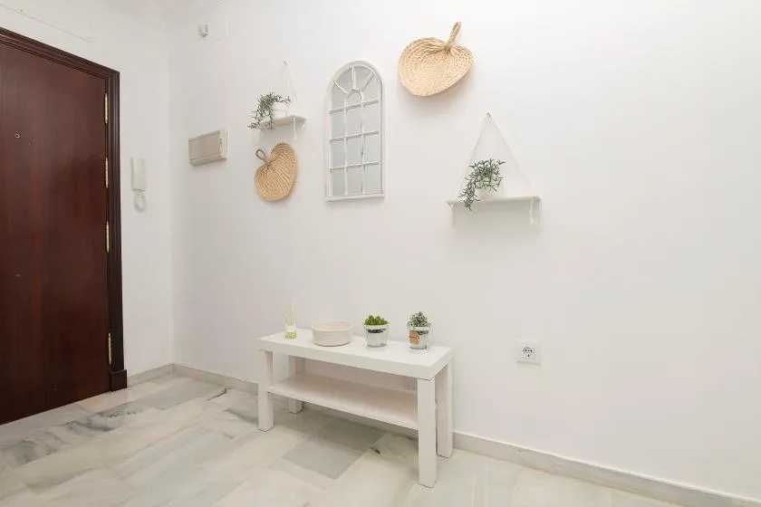 A bright entryway with a dark wooden door and a small white console table.