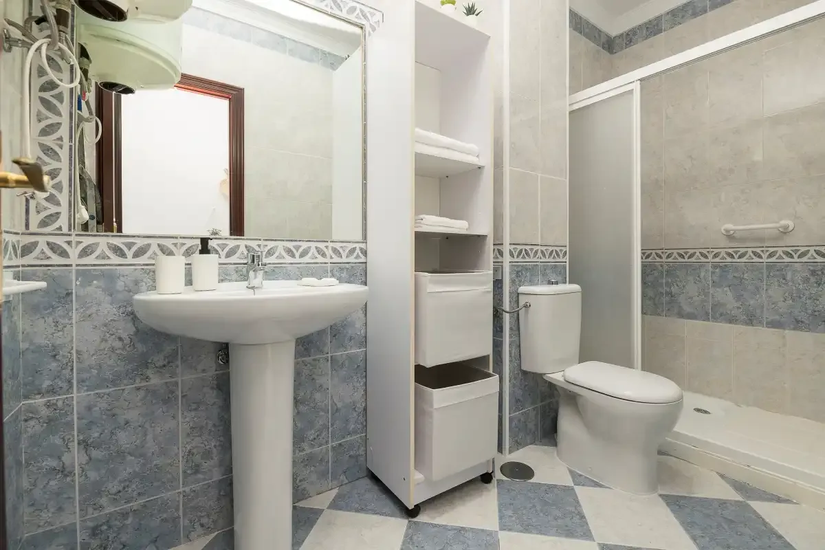 A tiled bathroom with a sink, toilet, and shower.