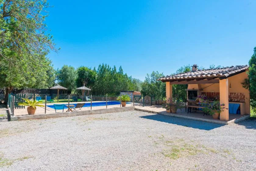Un patio exterior con piscina y una terraza cubierta.