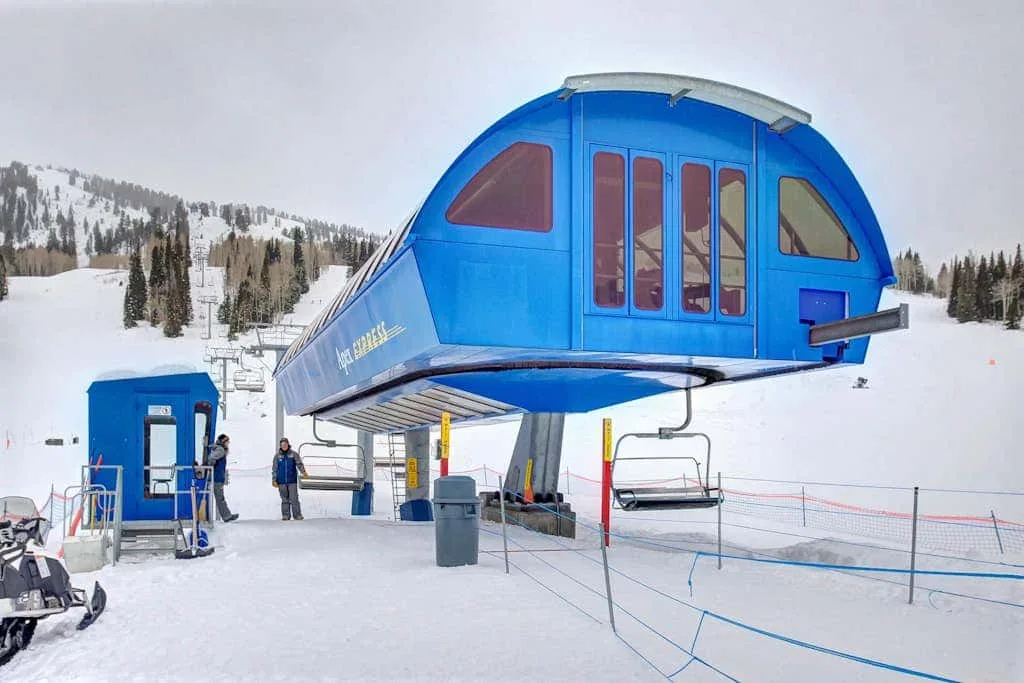 Una terminal azul de telesilla se encuentra en una ladera nevada.