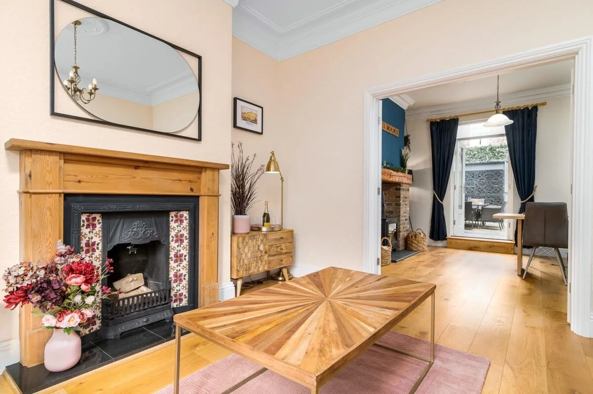 A bright living room with a wooden fireplace and a low coffee table.