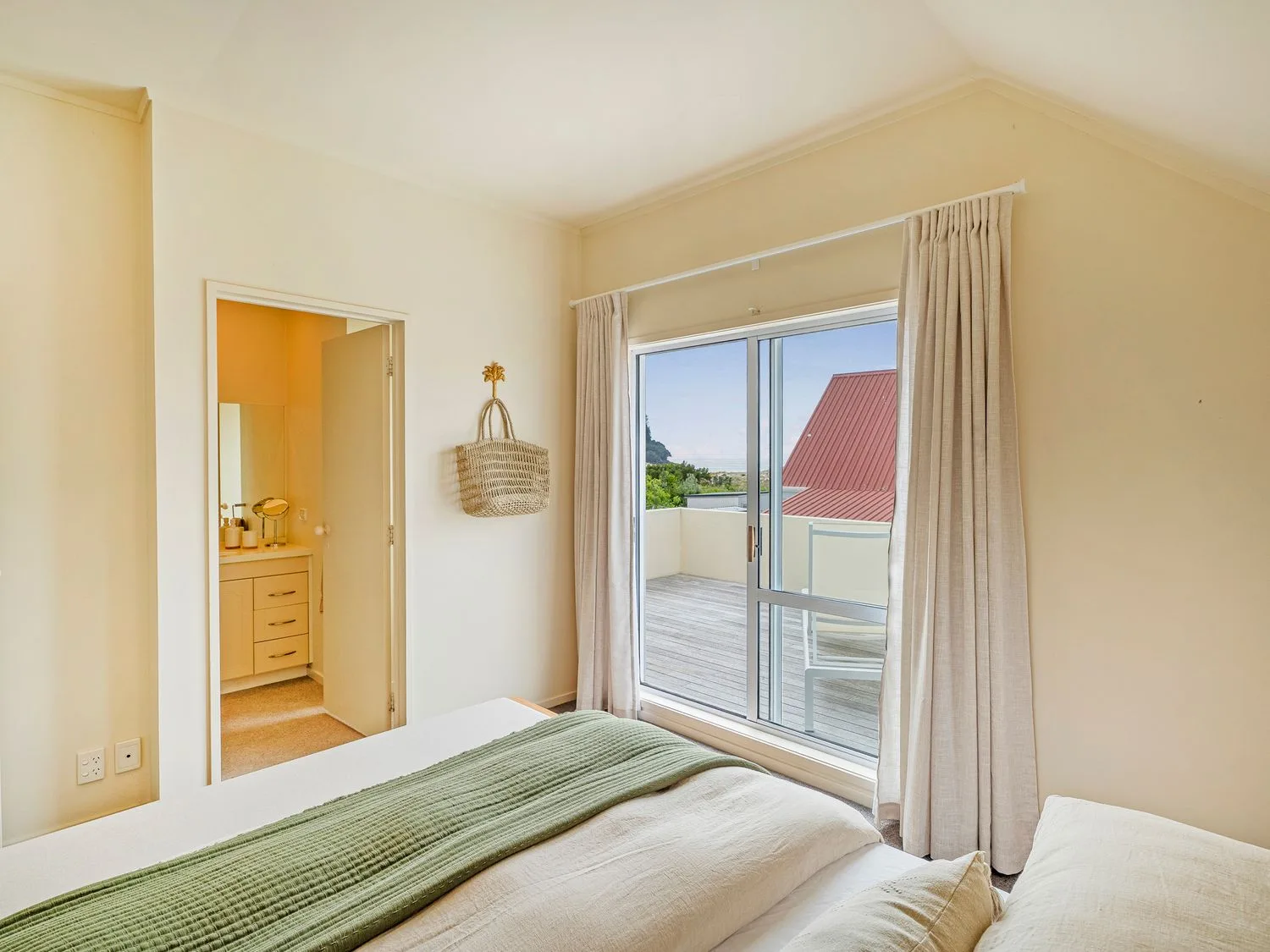 Un dormitorio con una cama junto a puertas corredizas de vidrio que dan a un balcón.