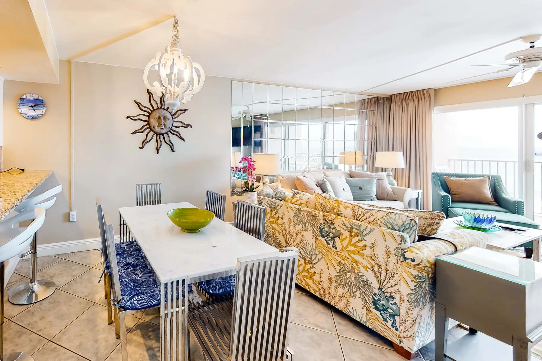 A bright open-plan living and dining area with patterned seating and a dining table.