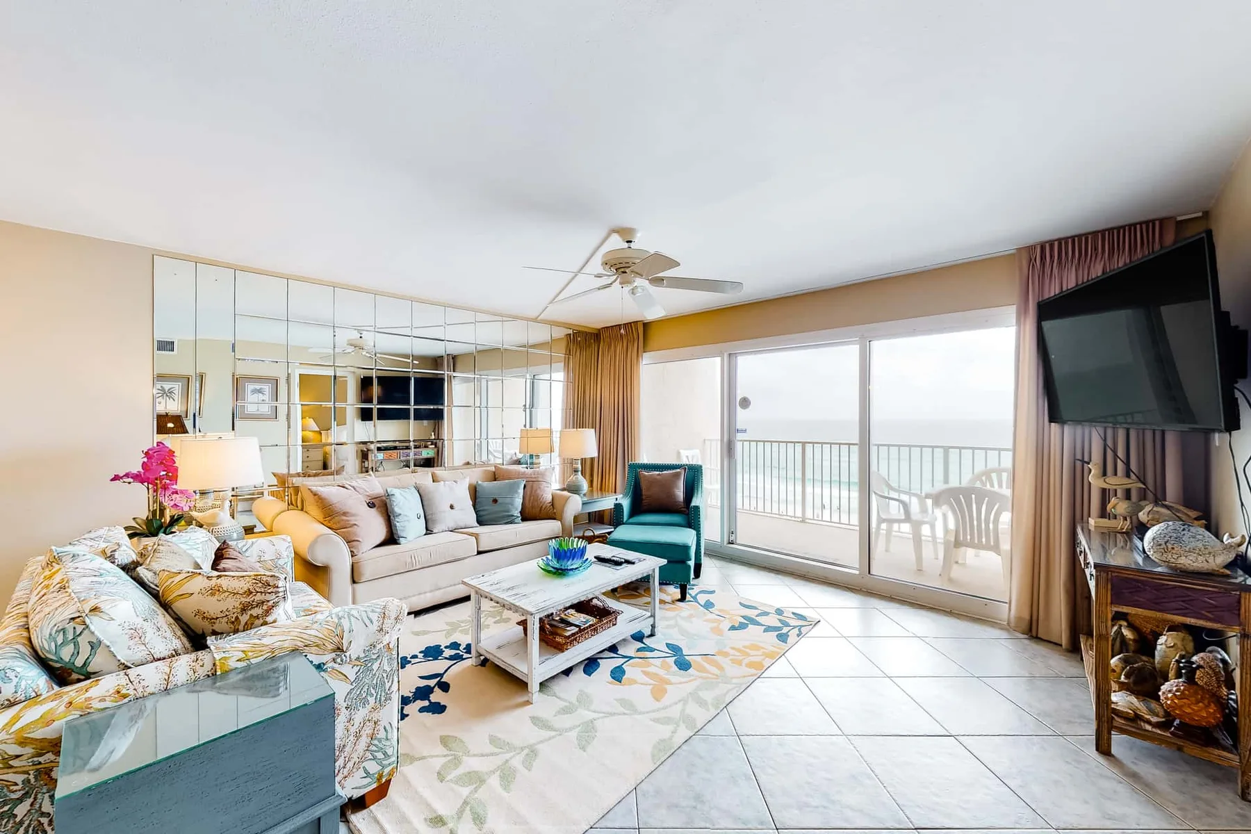 A bright living room with seating, a coffee table, and sliding glass doors to a balcony.