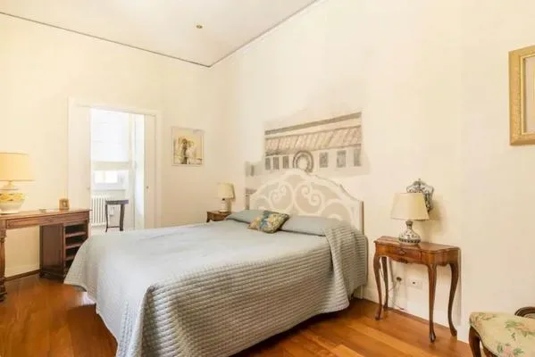 Dormitorio con una cama, mesillas de noche y cuadros en las paredes.