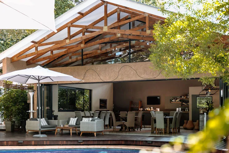 Open-air lounge, bar and poolside seating under a timber roof