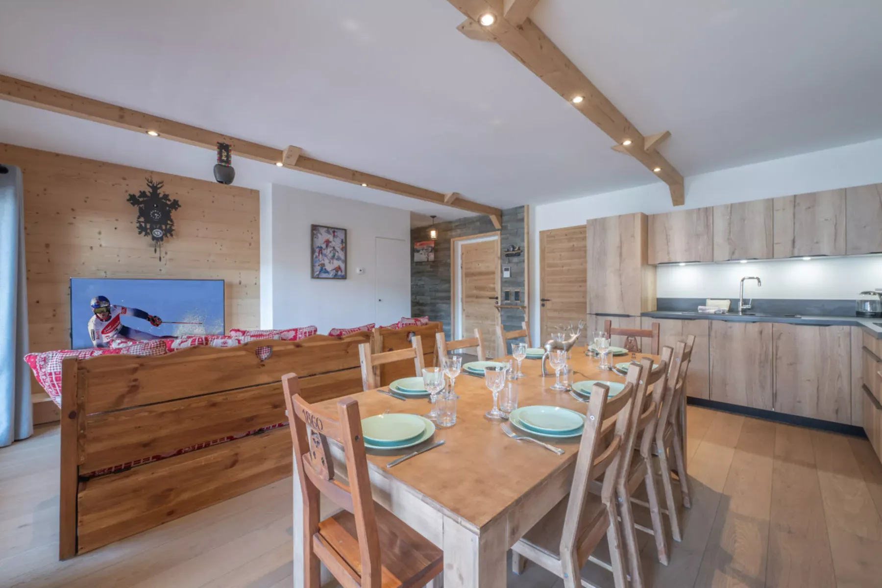 A dining area with a wooden table and chairs beside a compact kitchen.
