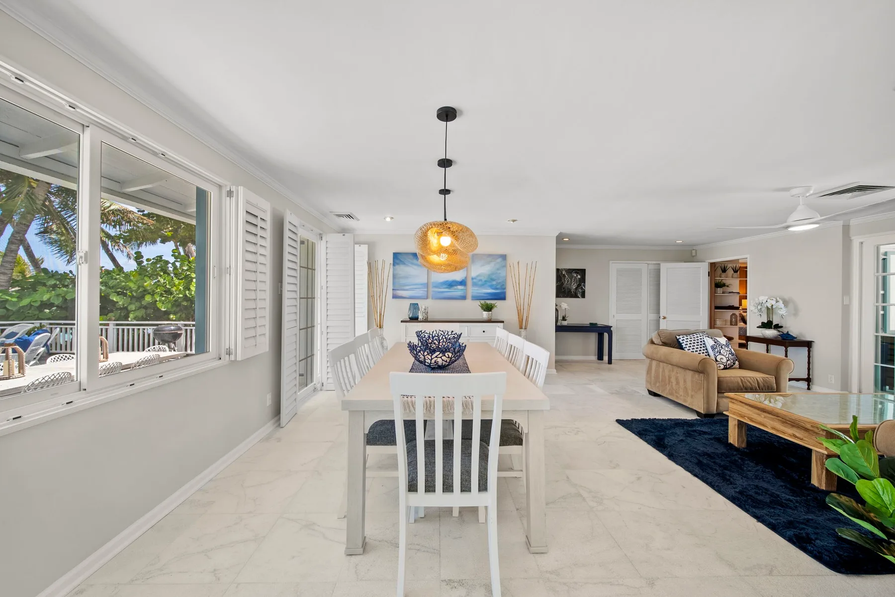 Un salón-comedor luminoso y diáfano con una mesa larga y una zona de asientos.