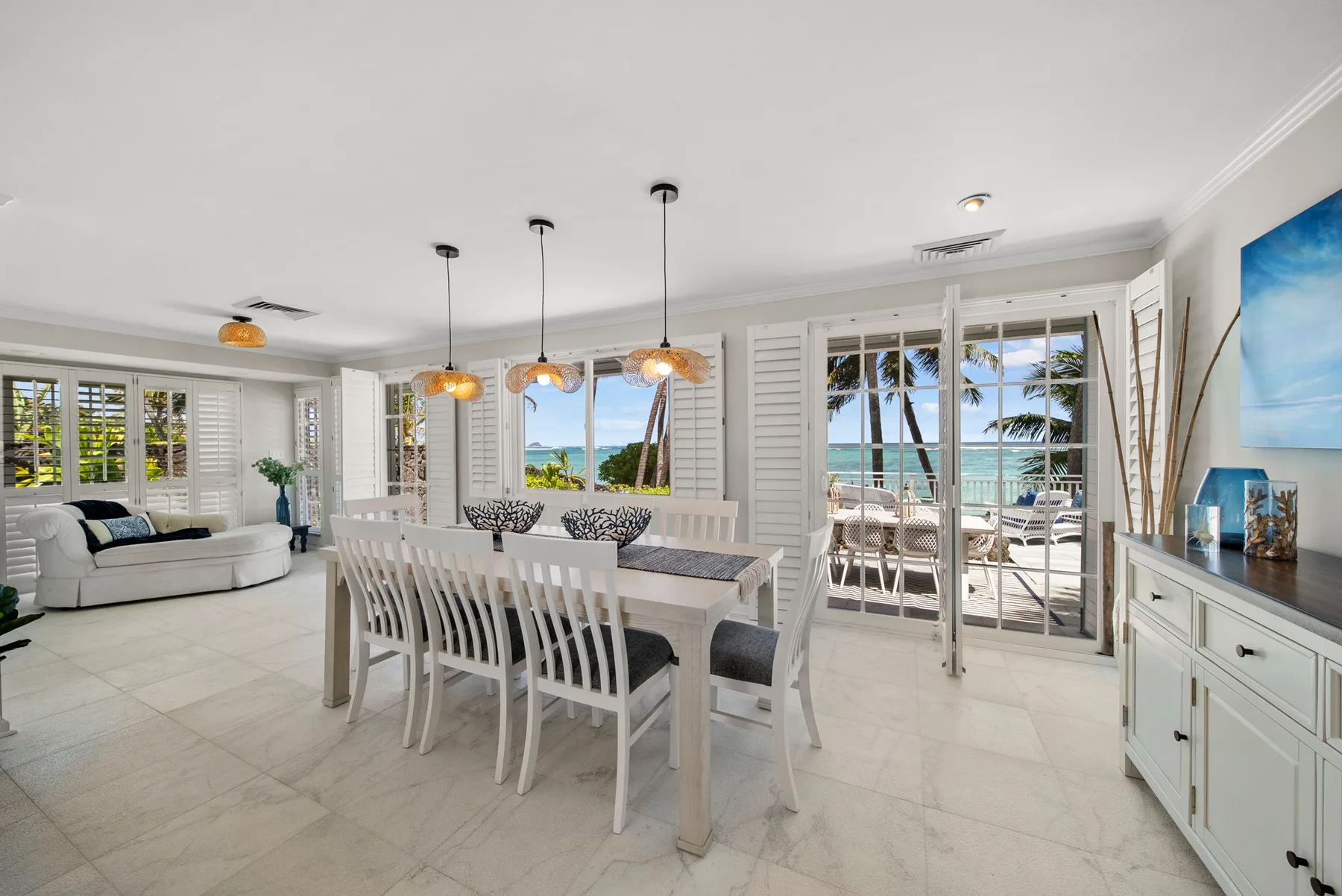 Un luminoso comedor y sala de estar se abre a un patio con vista al mar.