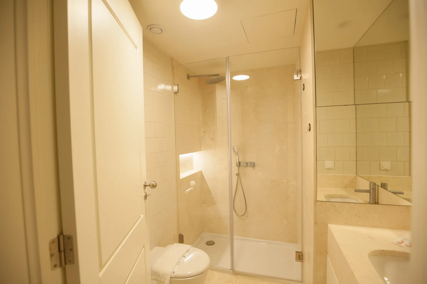 A bathroom with a glass shower and a sink.
