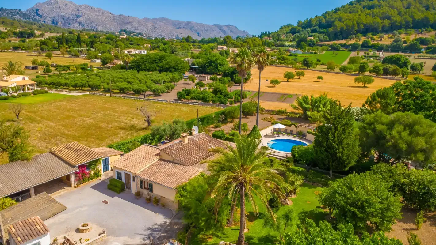 Aerial view of a house, pool, and surrounding countryside.