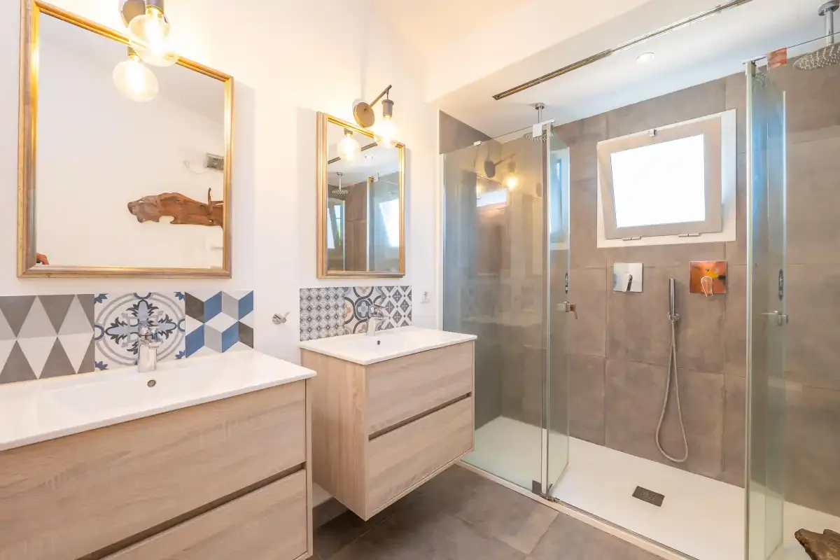 A bathroom with two sinks and a glass-enclosed shower.