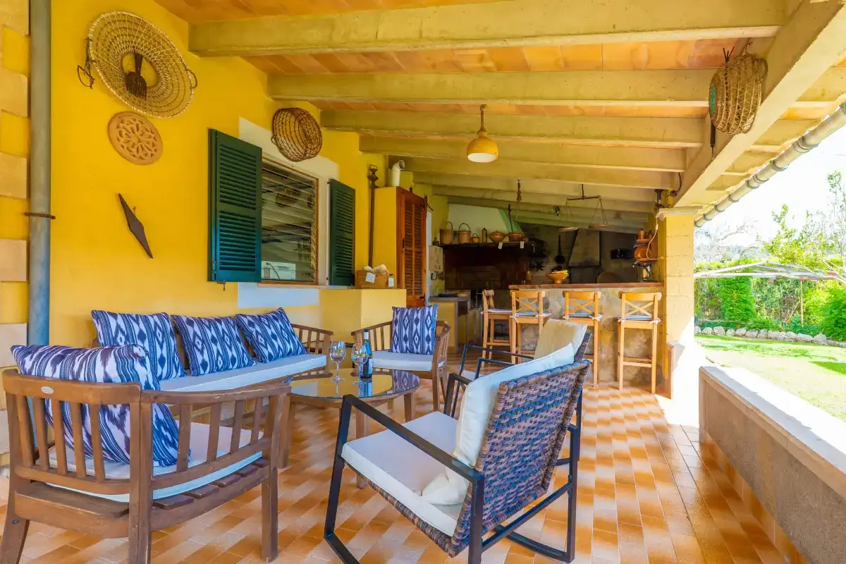 Covered outdoor seating area with tables, chairs, and a counter.