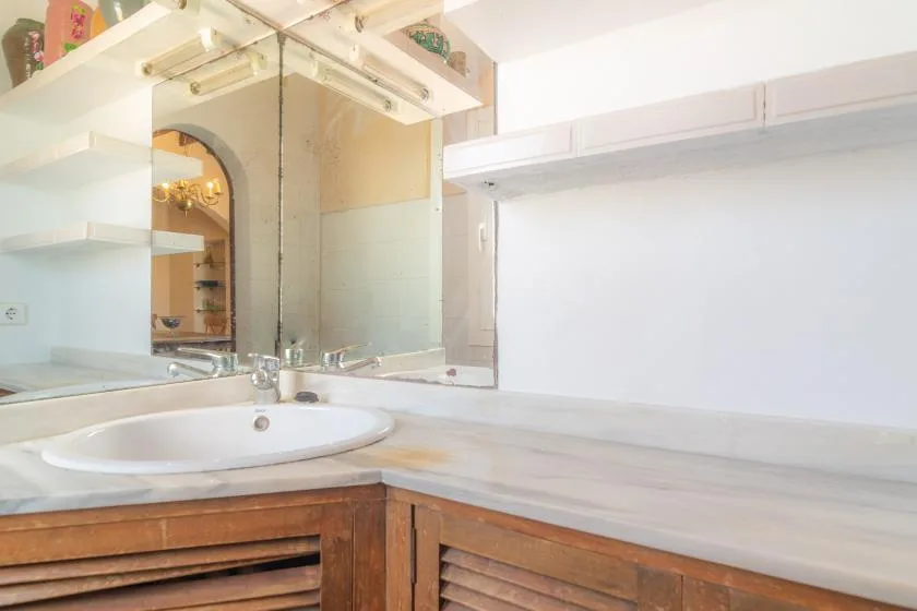A bathroom vanity with a sink and large mirror.