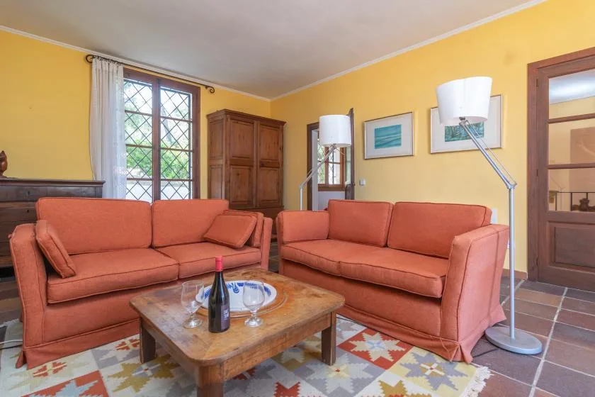 A living room with two salmon-colored sofas around a low wooden coffee table.
