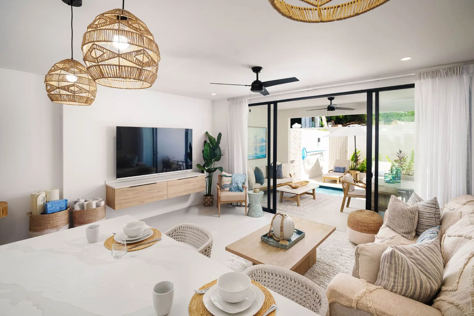 A bright living and dining area opens onto a patio through large sliding glass doors.