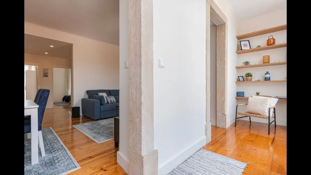 Una sala luminosa con asientos y un pequeño espacio de trabajo junto al pasillo.