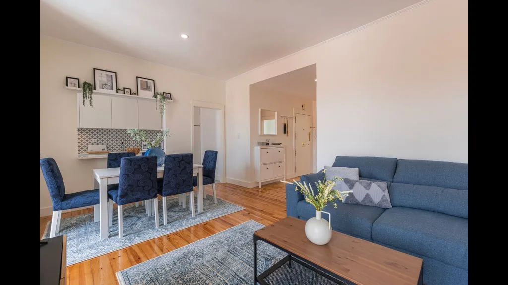 Una sala-comedor de concepto abierto con asientos azules y una mesa de comedor.