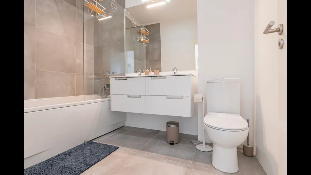 Un baño moderno con bañera, lavabo y sanitario.