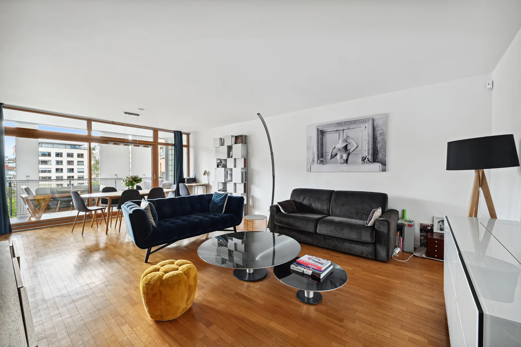 A bright living room with seating, coffee tables, and large windows.