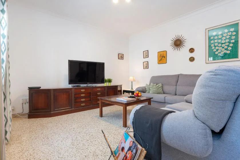Living room with gray seating, a television, and a coffee table.