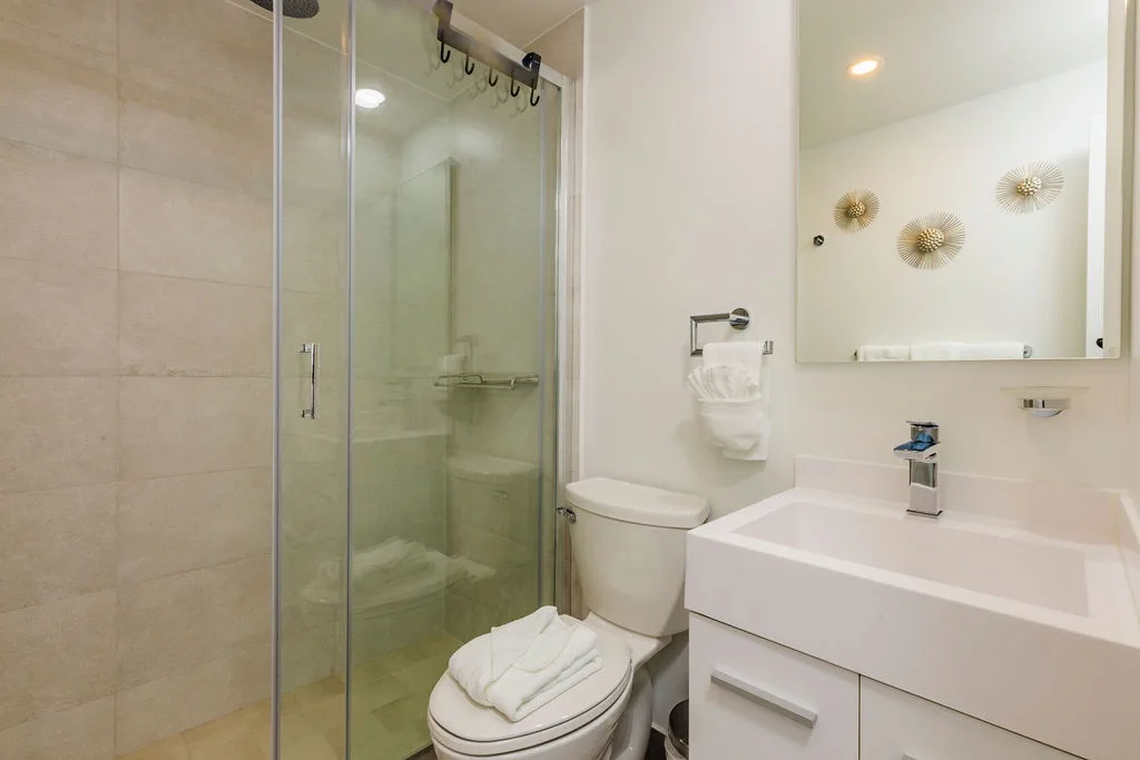 A clean, modern bathroom awaits you with a glass-enclosed shower, sleek sink, and elegant touches that make your daily routine feel special.