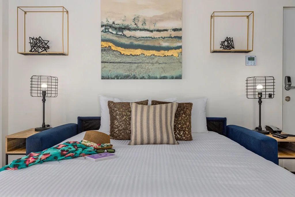 Your coastal retreat awaits with a plush bed, ocean-inspired art, and modern touches. Unwind under warm lighting and let the soothing décor melt your stress away.