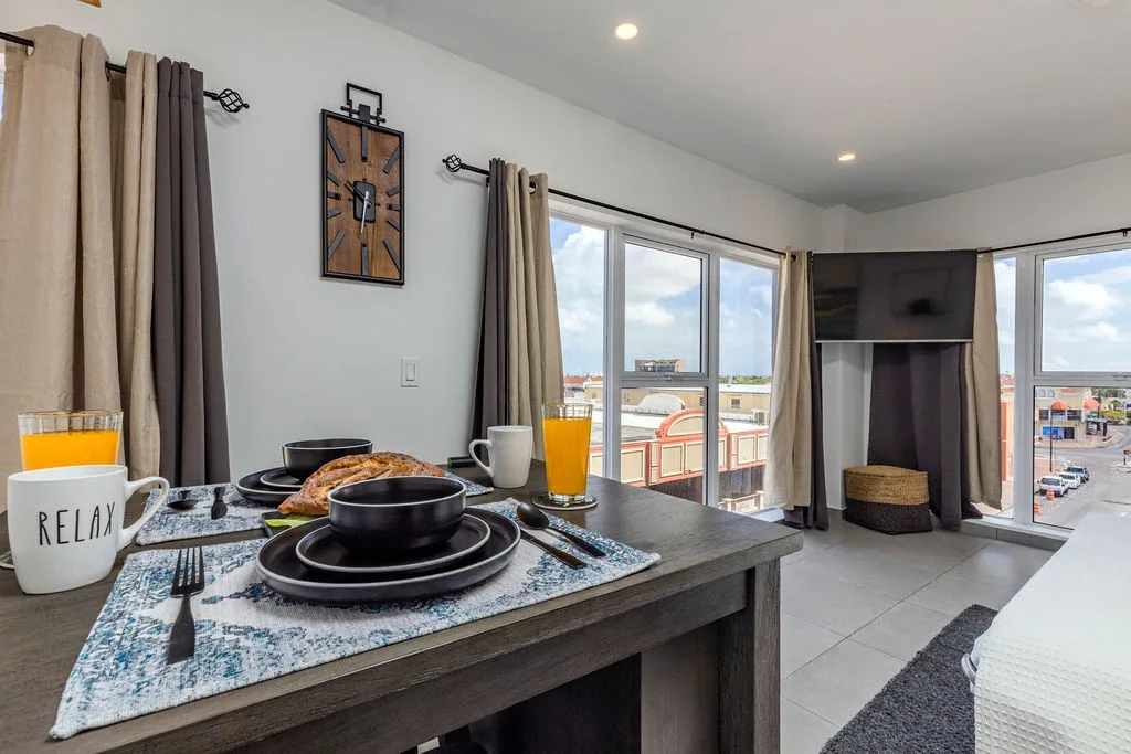 Start your mornings with fresh juice and pastries at your own dining table while city views stretch out beyond bright windows, inviting you to explore after breakfast.