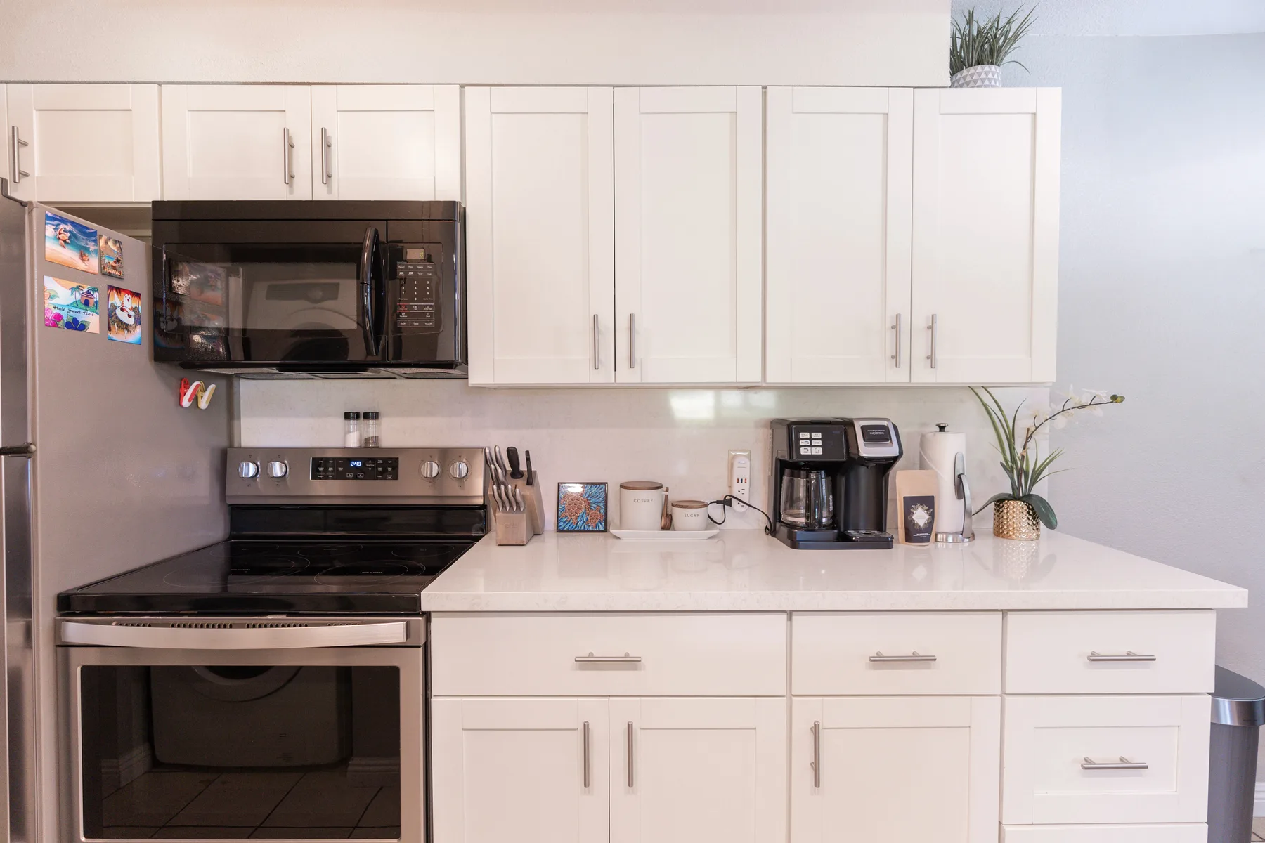 A bright kitchen with white cabinetry and stainless steel appliances.