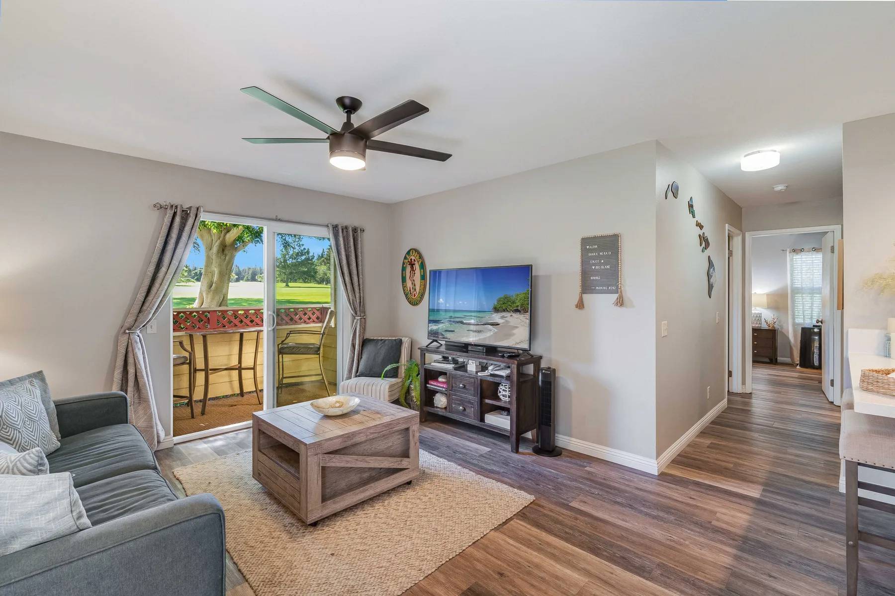Living room with seating, a coffee table, and sliding glass doors opening onto a patio.