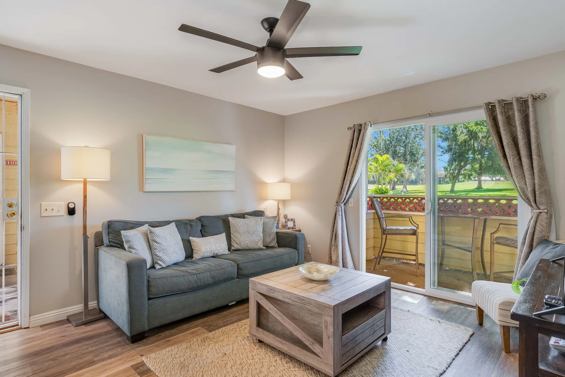 A living room with seating, a coffee table, and sliding glass doors to a patio.