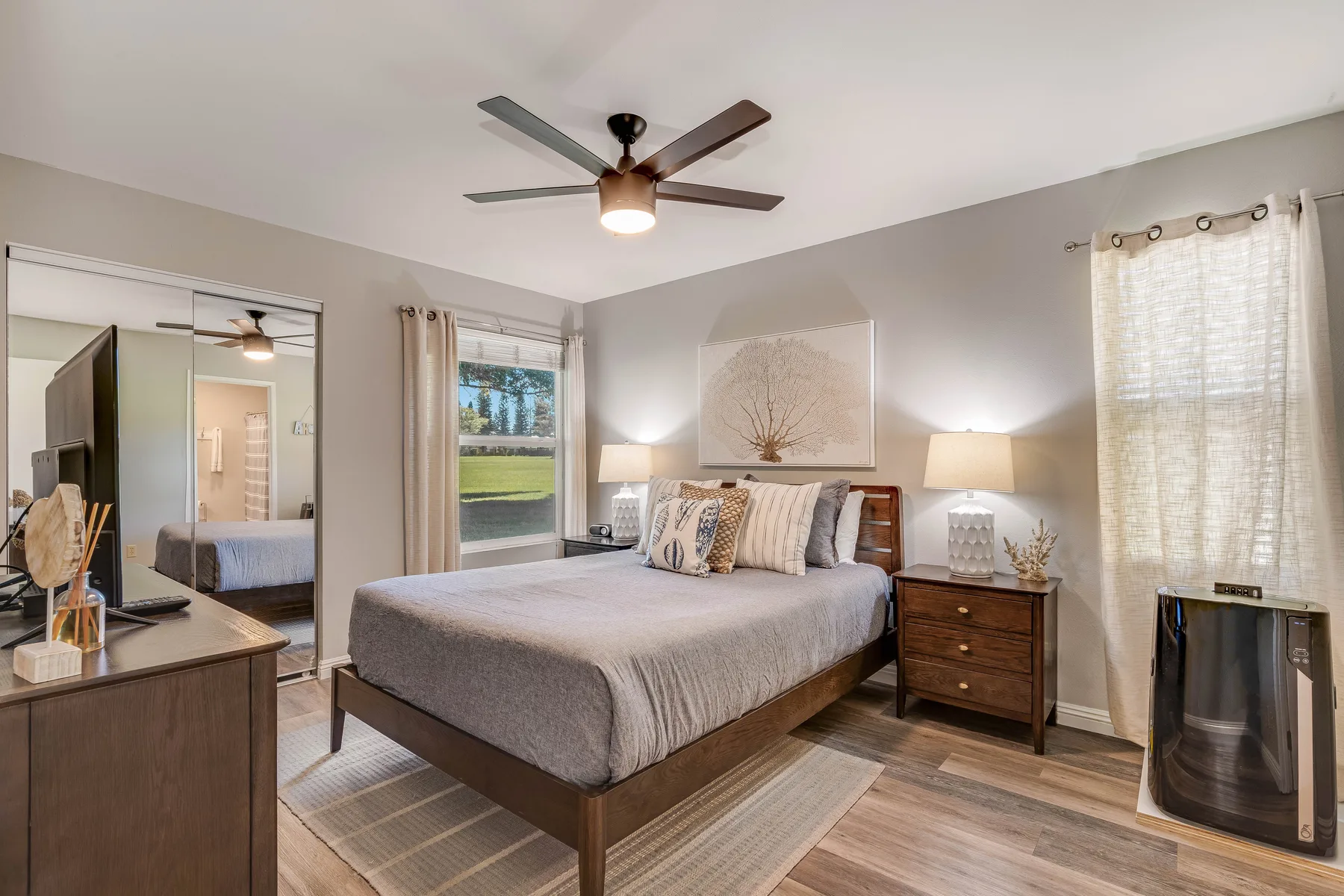 A bedroom with a bed, bedside tables, and a ceiling fan.