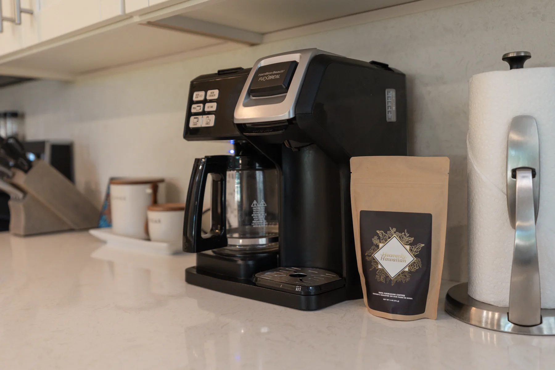 A kitchen counter with a coffee maker and a paper towel roll.
