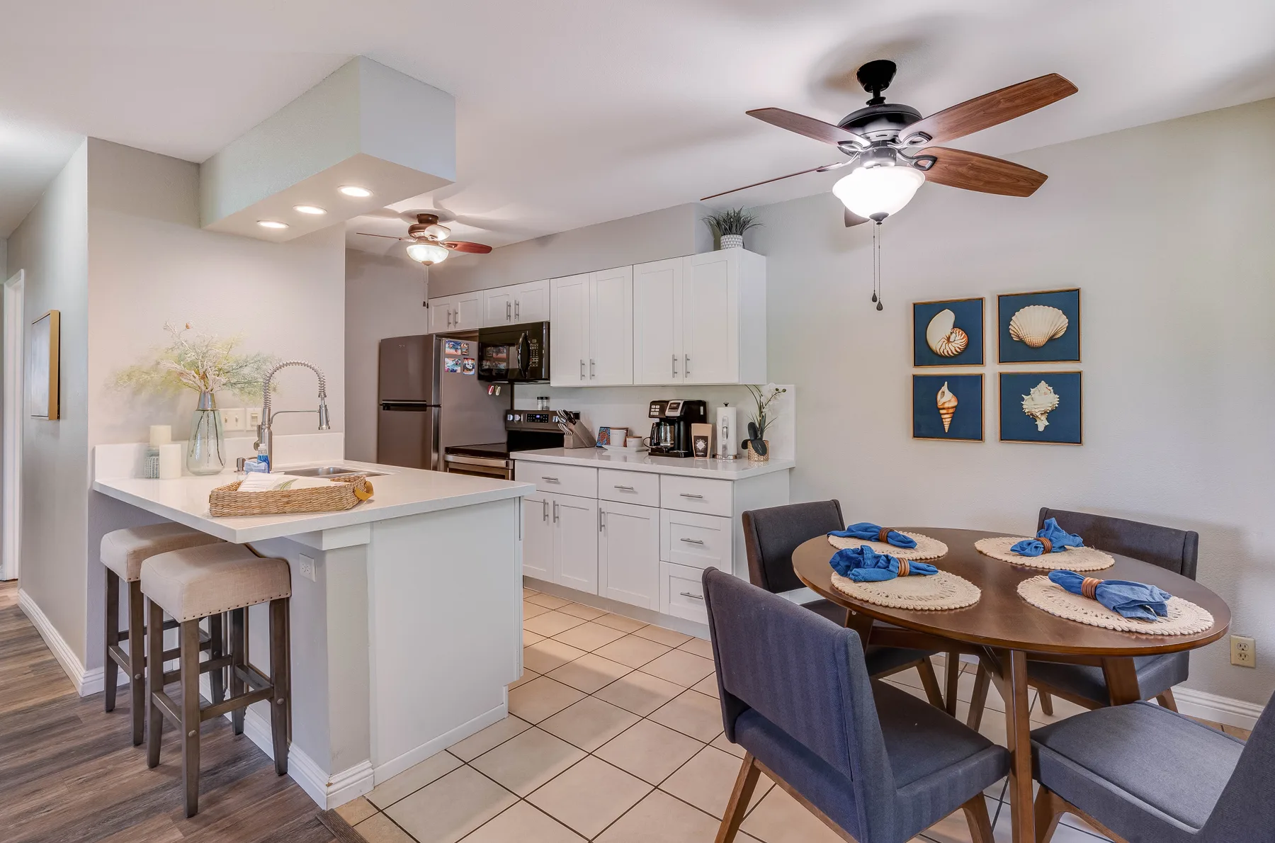 An open kitchen and dining area with white cabinets and a table set for a meal.
