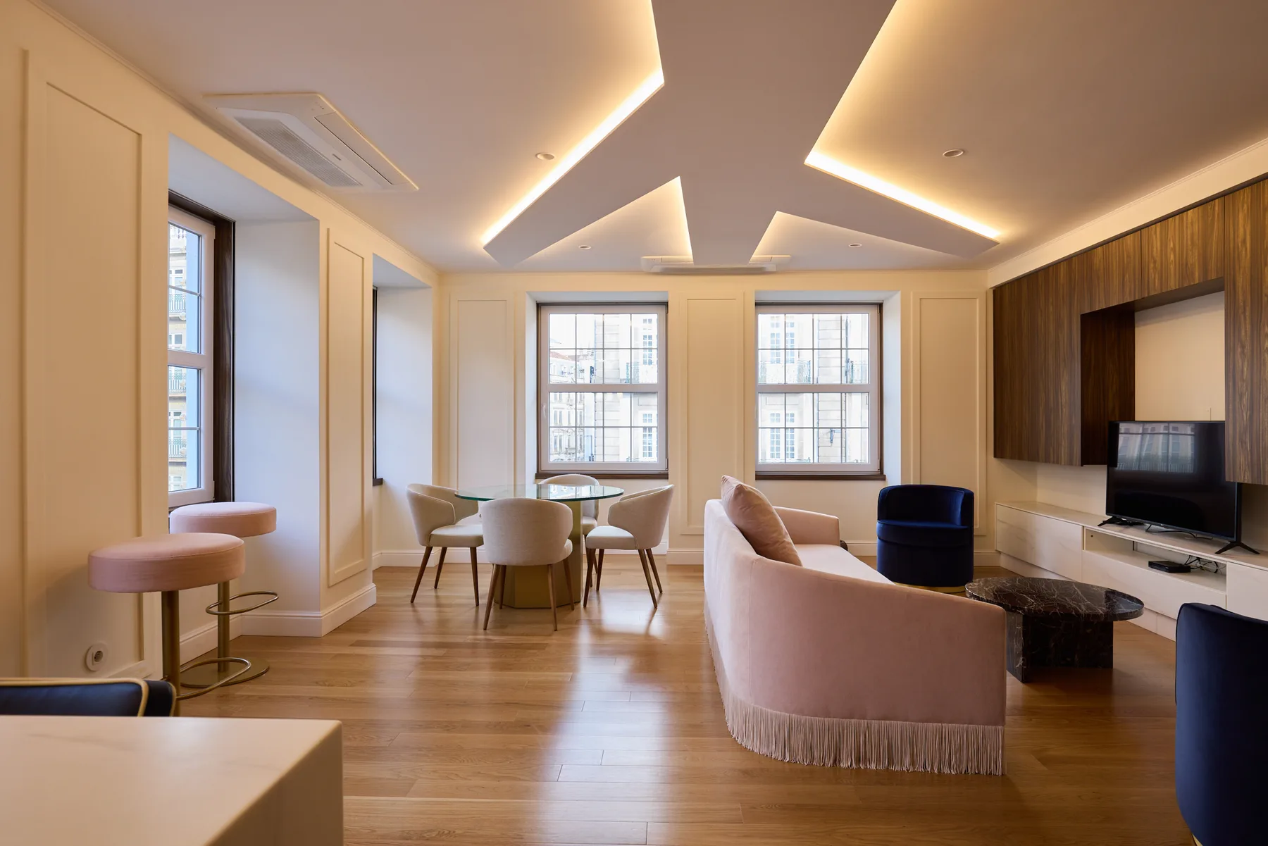 A living room with seating, a dining table, and a television.