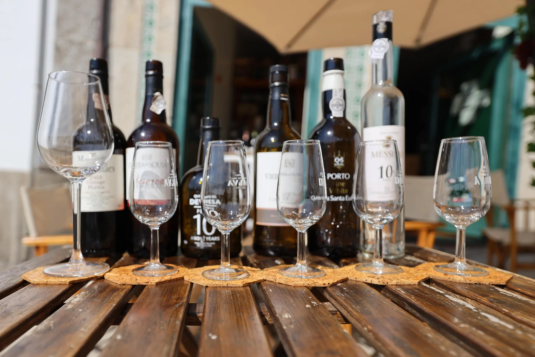 A wooden table displays several wine bottles and tasting glasses.