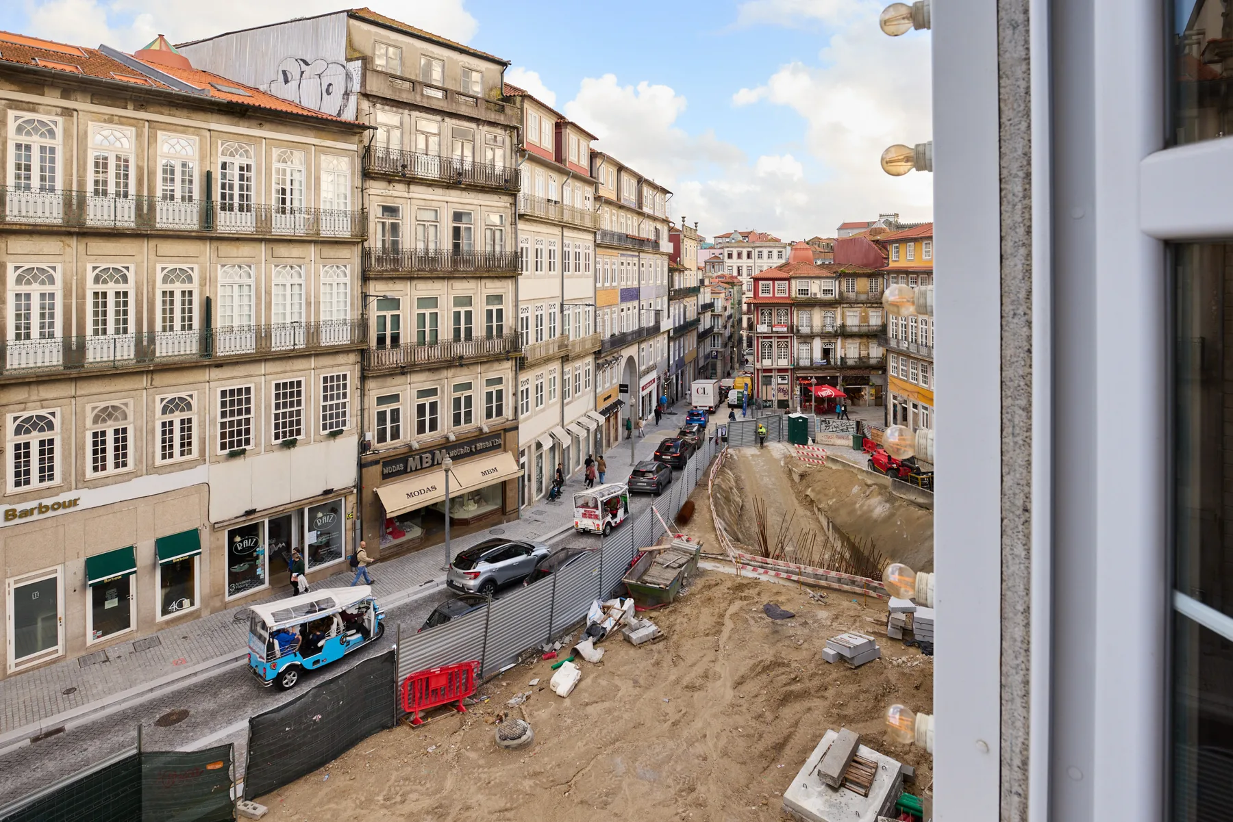A city street lined with historic buildings and an active construction site.