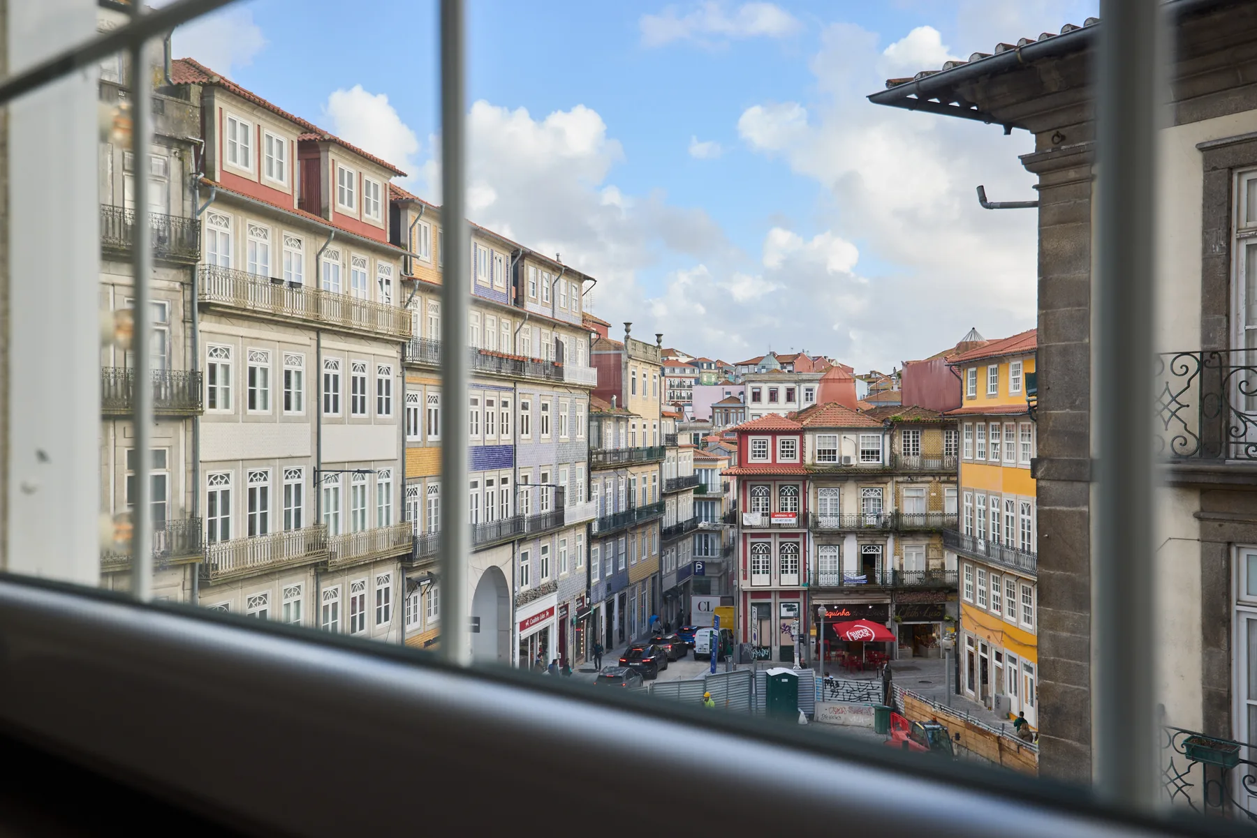 View of colorful buildings along a city street from a window.