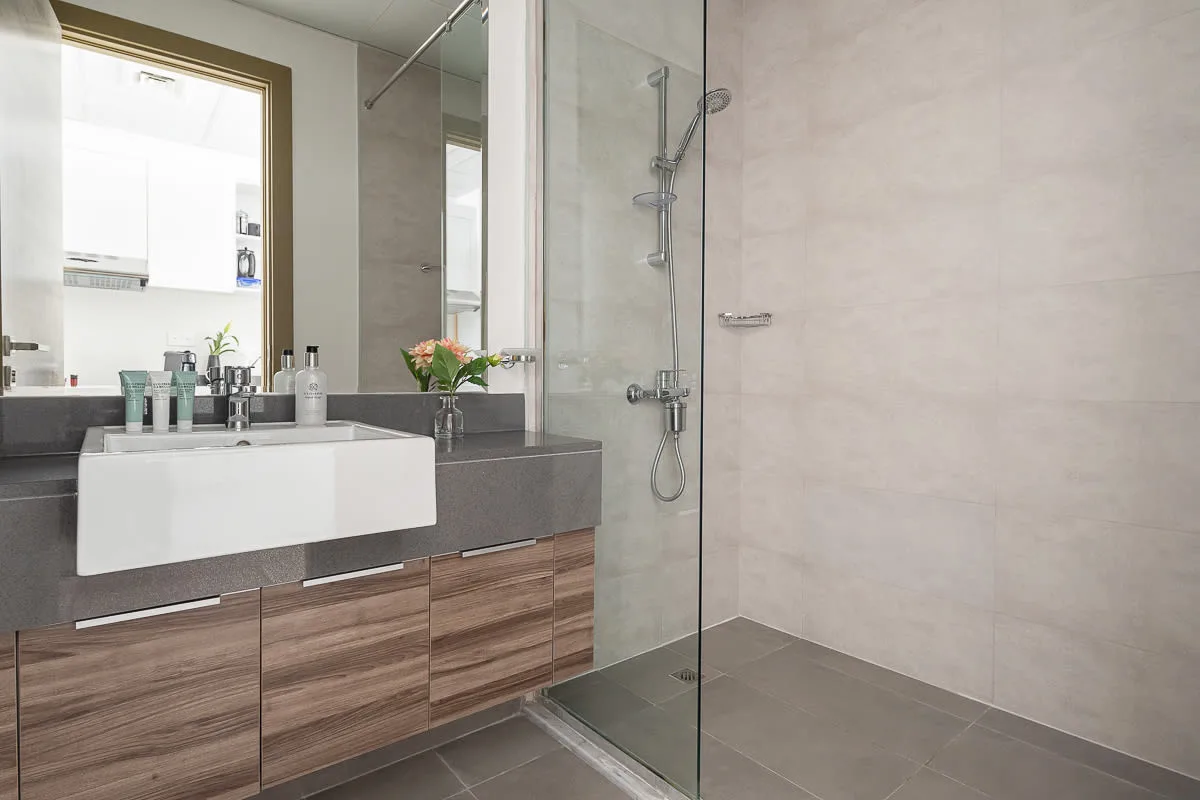 A modern bathroom with a vanity and glass shower.