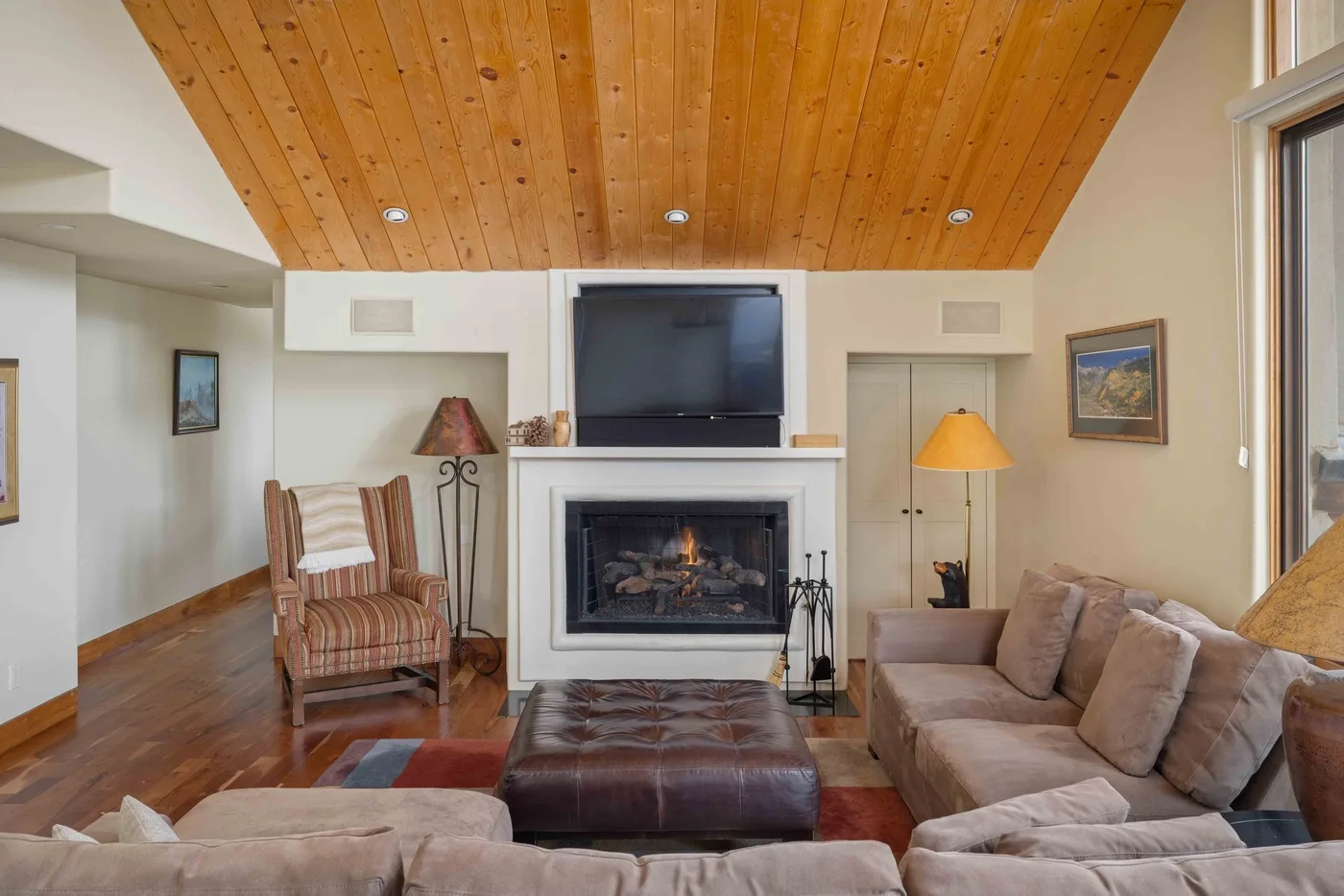 Una sala de estar con asientos alrededor de una chimenea y un televisor.