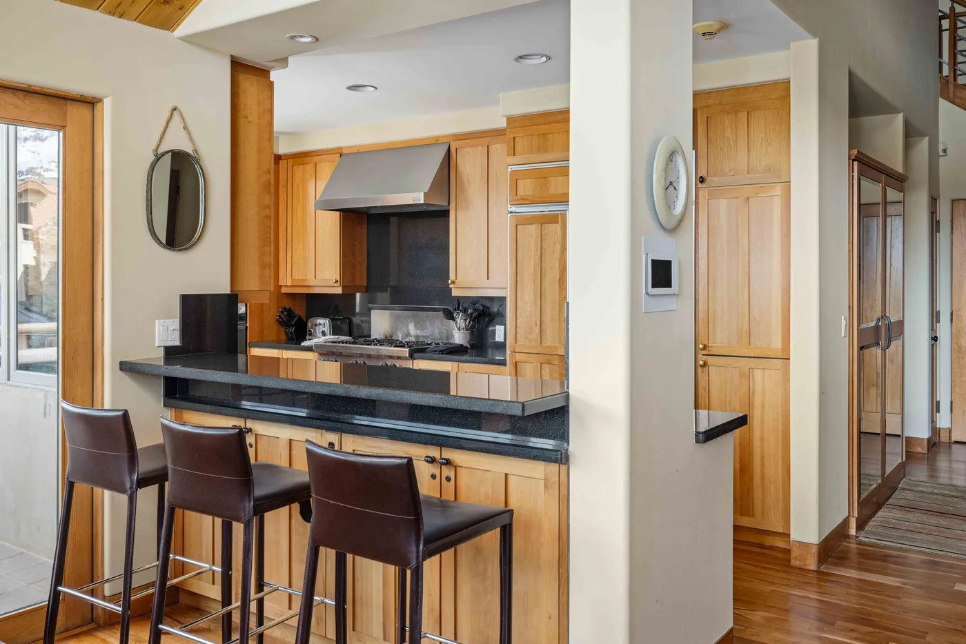 Una cocina con gabinetes de madera y una barra con asientos.