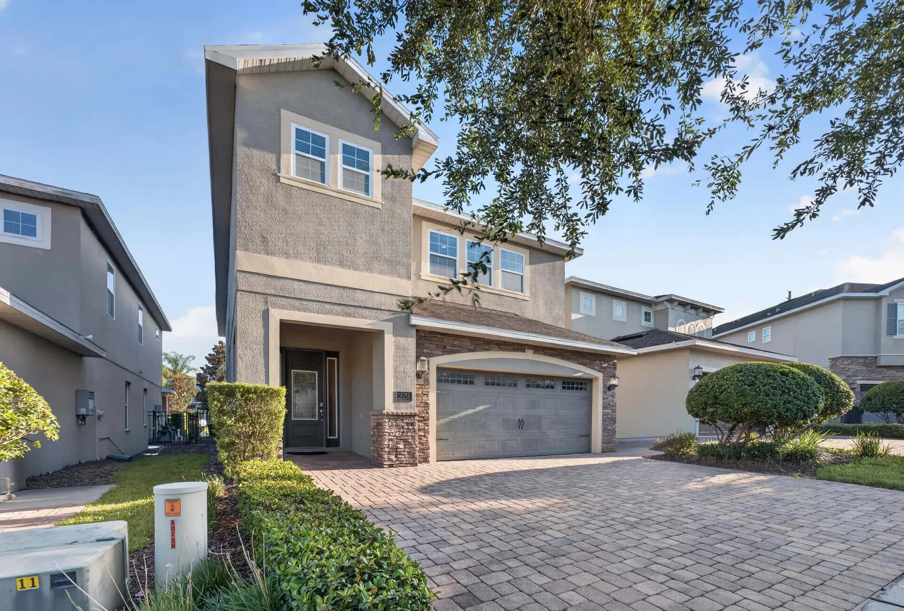A two-story house with an arched garage and a paved driveway.