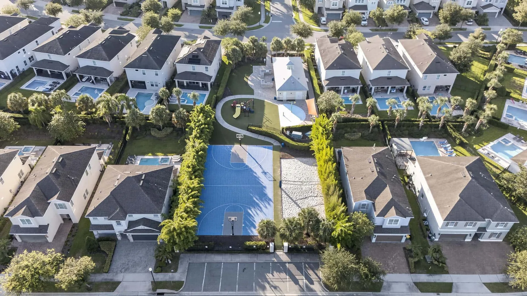 An aerial view of a residential neighborhood with a blue sports court.