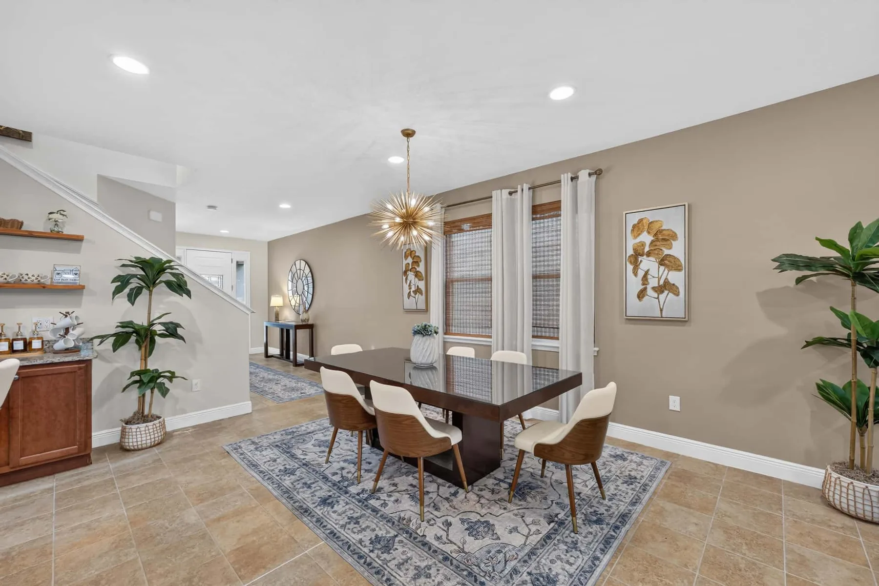A dining area with a table and chairs sits on a patterned rug.