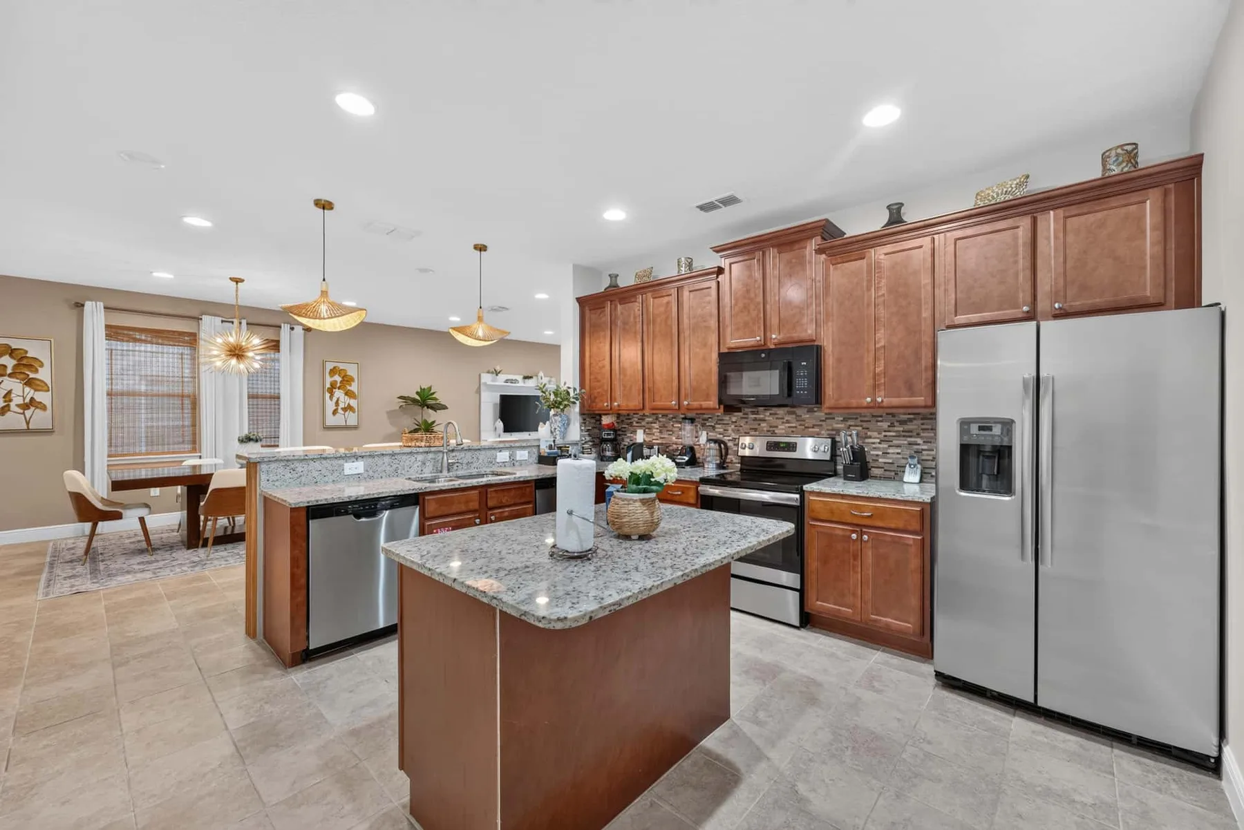 A spacious kitchen with wooden cabinets, stainless steel appliances, and a central island.