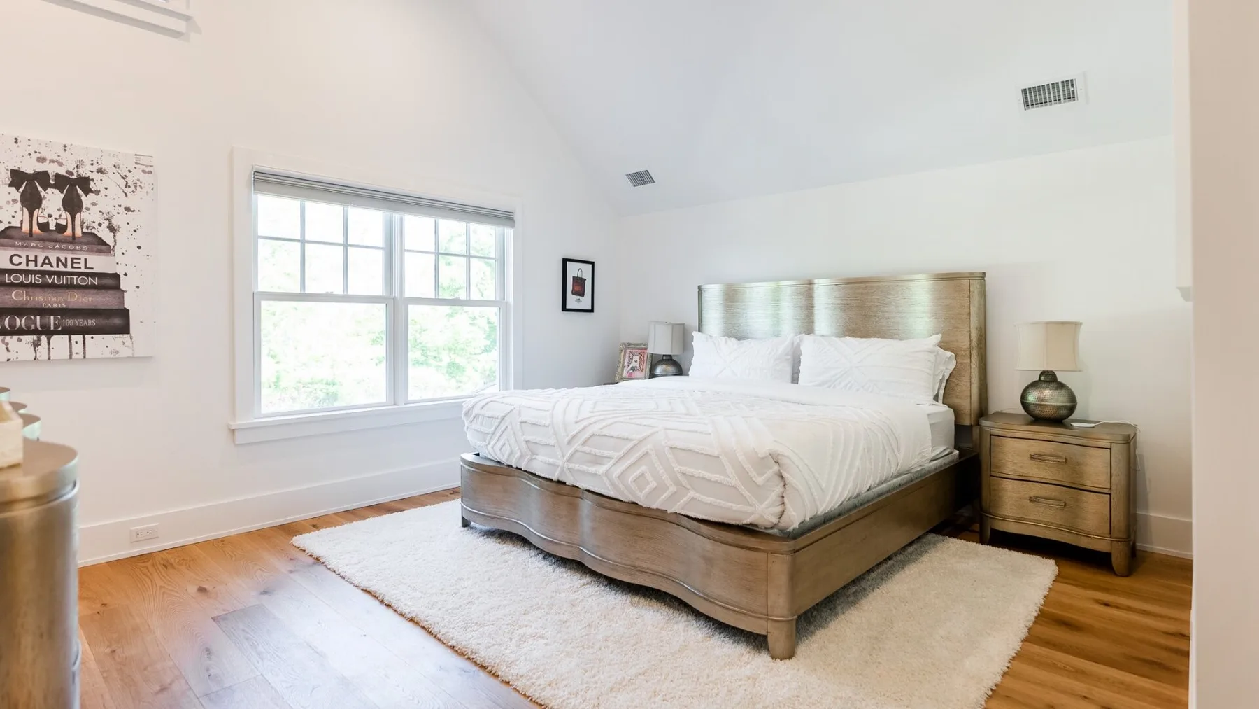 A bedroom with a large bed, bedside table, and area rug.