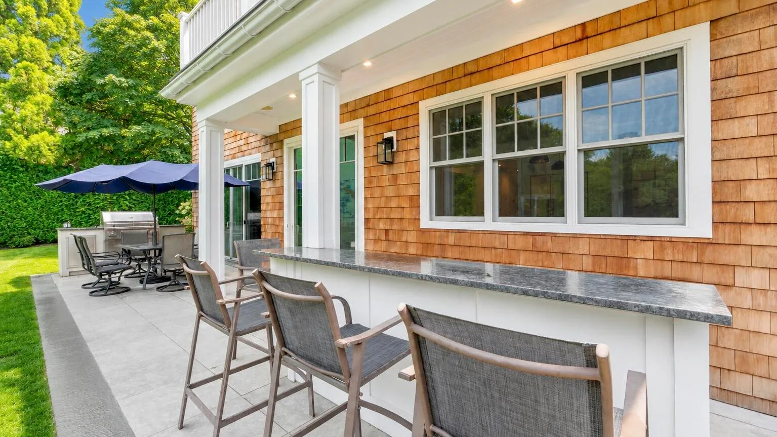 A covered outdoor patio with counter seating beside the house.